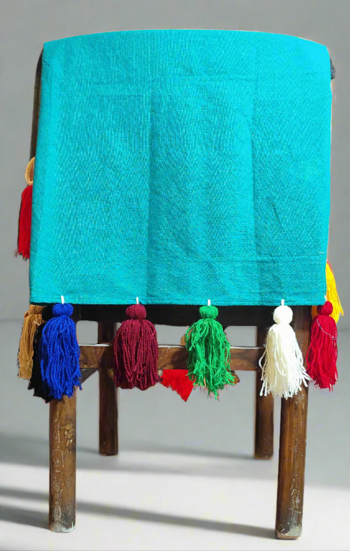 Emerald green chair cover with colourful tassel