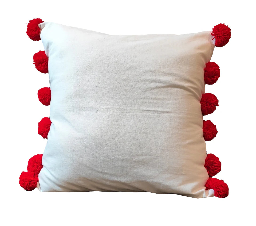 White cushion cover with red pompom balls