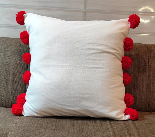 White cushion cover with red pompom balls